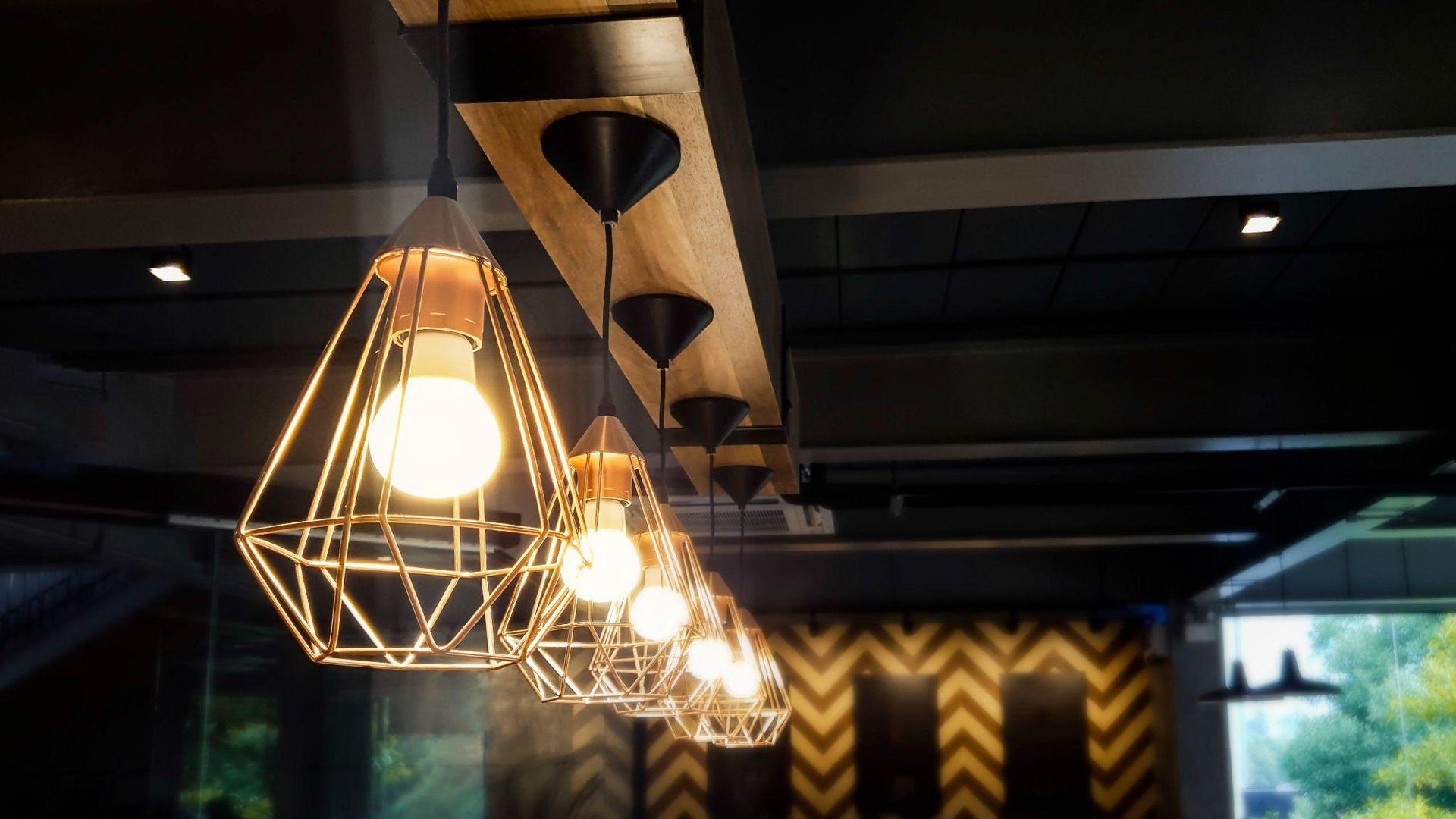 The antique retro interior design of electric light bulb décor hanging on the ceiling in a dark restaurant.