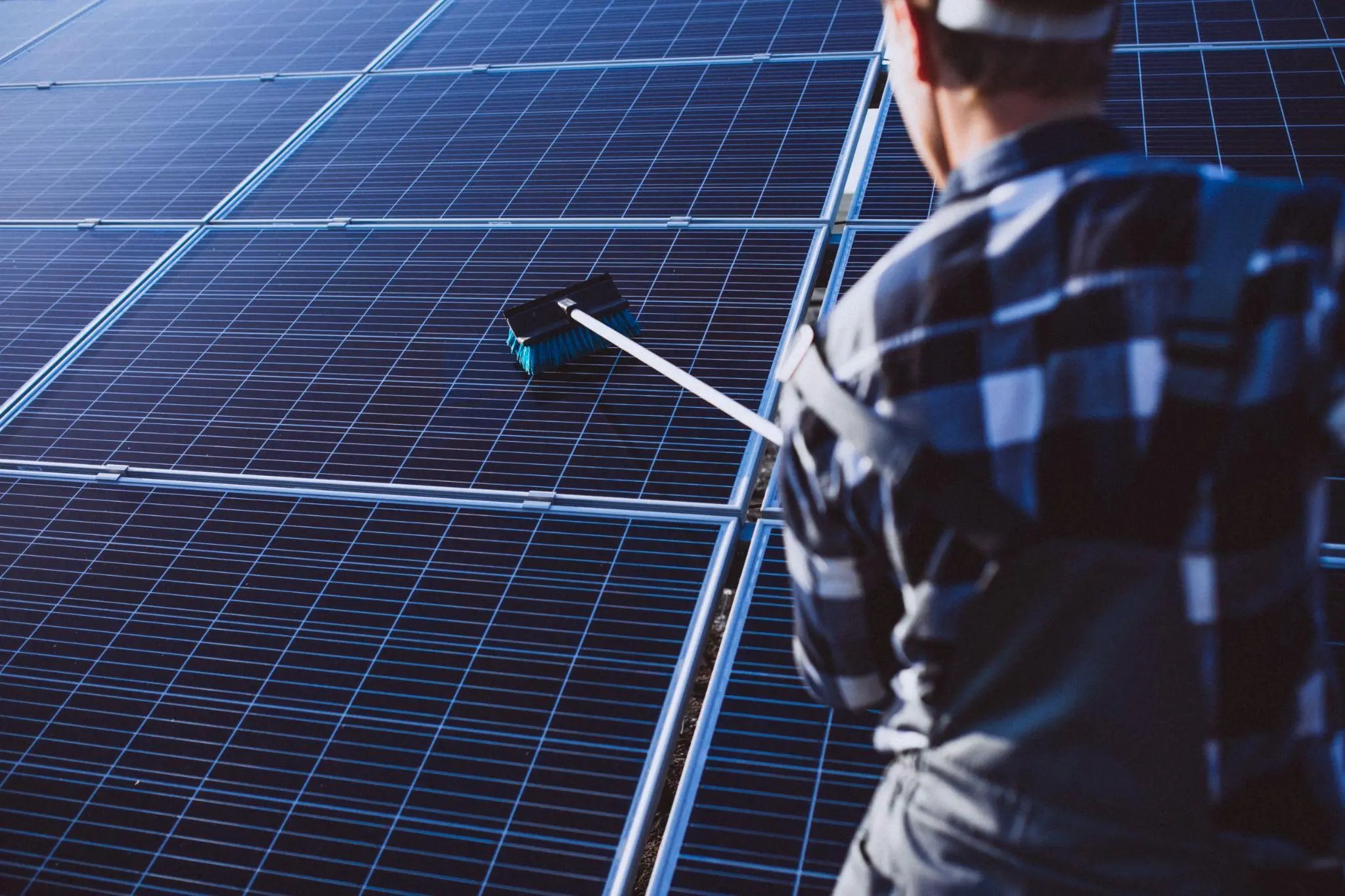 A worker is brushing solar panels.