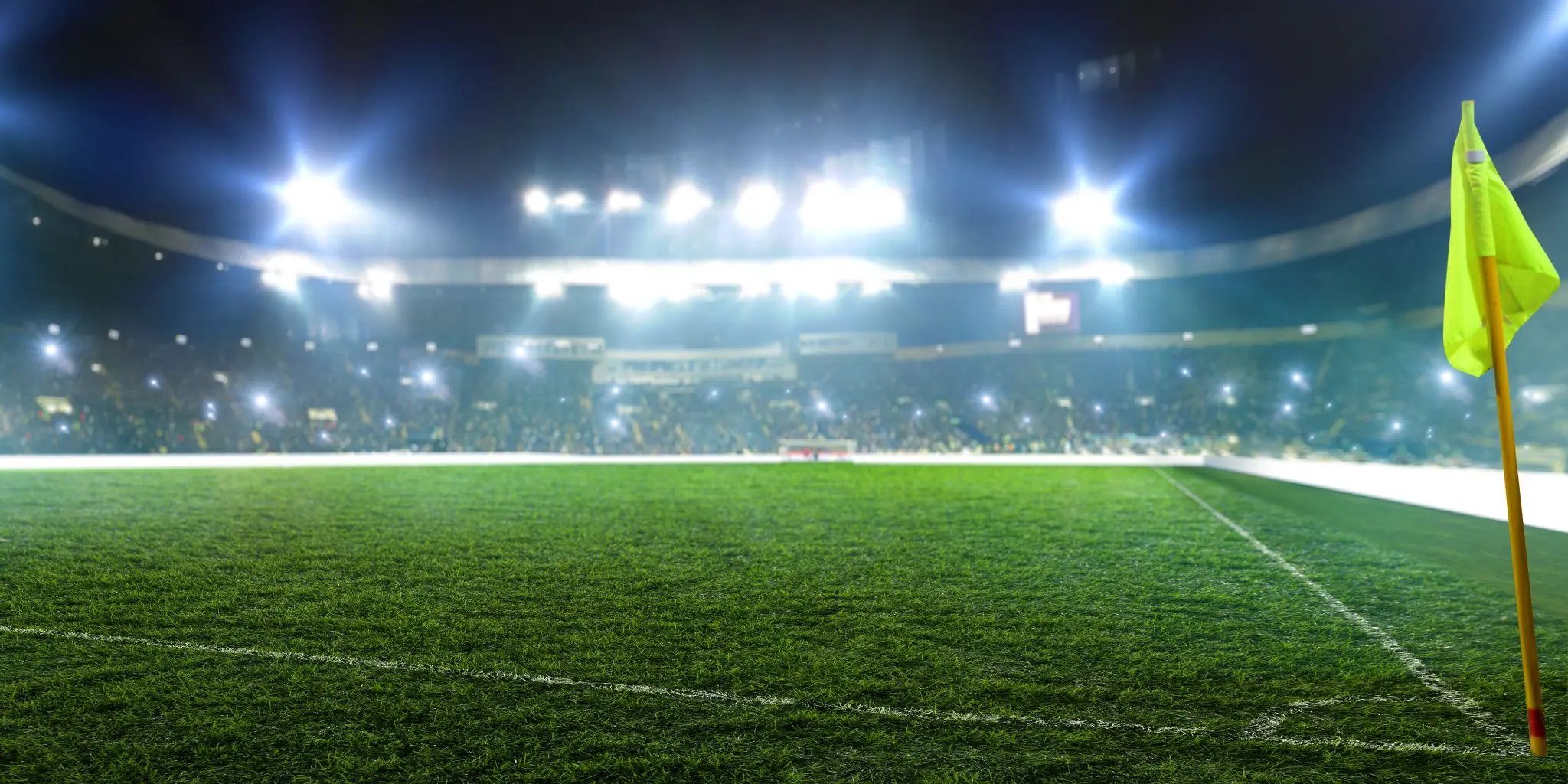Football stadium, corner flag, shiny lights, view from field grass