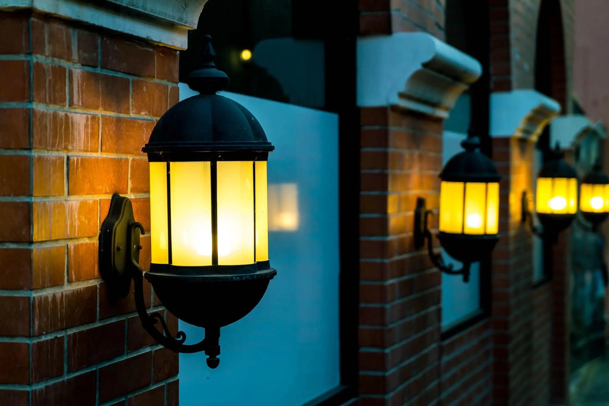 lamp against a red brick wall at night